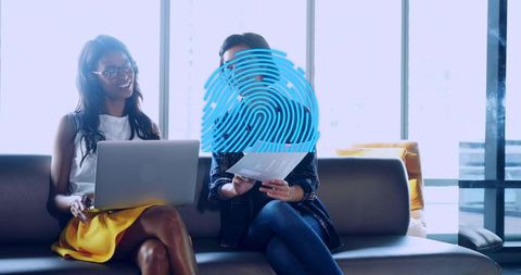 Collaborating professionals using laptop and documents with digital fingerprint security overlay