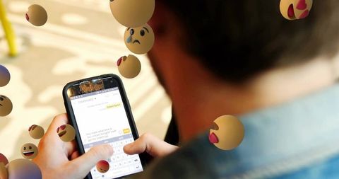 Man Messaging on Smartphone with Floating Emoji Expressions