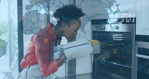 Home baker removing fresh loaf from oven with mitts, world map overlay in smart kitchen