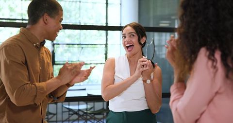 Diverse office colleagues celebrating team success