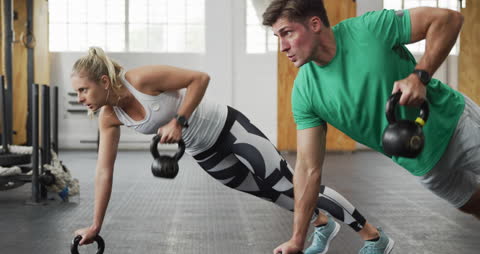 Athletes Performing Kettlebell Workout in Gym