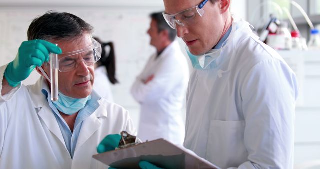 Scientists Conducting Experiment in Laboratory with Test Tubes and Clipboard - Download Free Stock Images Pikwizard.com