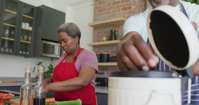 Mature Couple Preparing Meal in Modern Kitchen Wearing Aprons - Download Free Stock Images Pikwizard.com