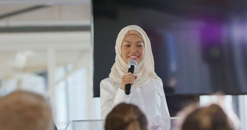 Confident businesswoman in hijab speaking at business conference