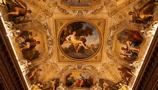 Gilded baroque ceiling with central classical fresco and ornate sculptural details
