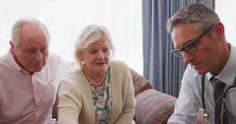 Senior Couple Discussing X-ray with Doctor at Home