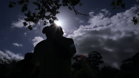 Silhouette of Man Relaxing in Moonlit Countryside