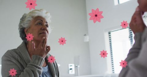 Senior Woman Admiring Her Reflection Surrounded by Pink Petals - Download Free Stock Images Pikwizard.com
