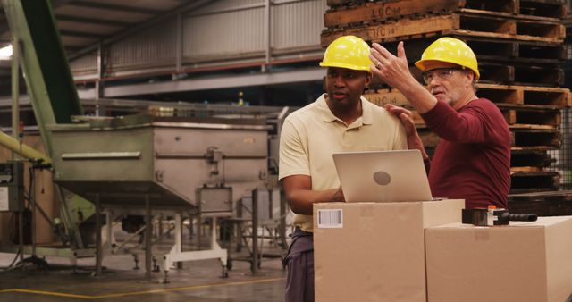 Engineers Collaborating in Manufacturing Warehouse with Laptop - Download Free Stock Images Pikwizard.com