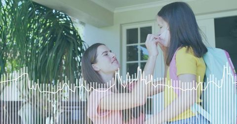Mother adjusting face mask for schoolgirl on porch with backpack and health waveform overlay