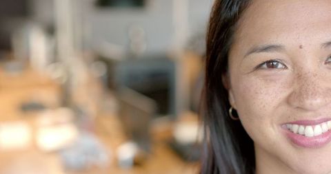 Confident Asian Businesswoman Smiling in Office Setting