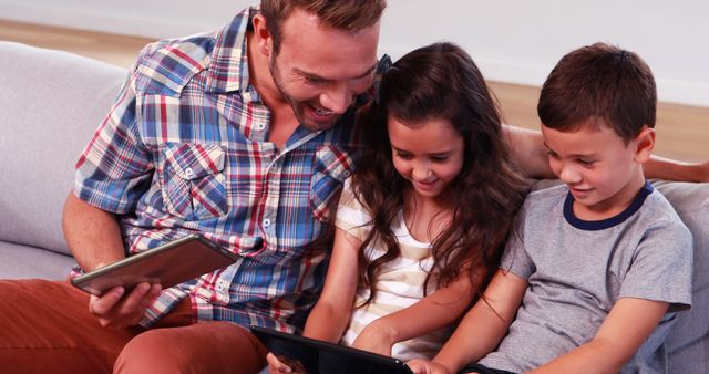 Father Sharing Digital Tablet Experience with Children on Sofa - Download Free Stock Images Pikwizard.com