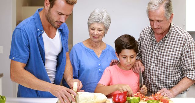 Multi-generational family in kitchen preparing a meal together. Adults and child cutting bread and vegetables, fostering teamwork and bonding. Ideal for websites and ads about family life, home cooking, togetherness, or healthy living.
