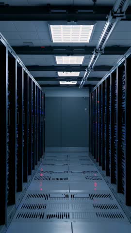 Vertical video gliding through data center aisle with LED server racks and cooling grates