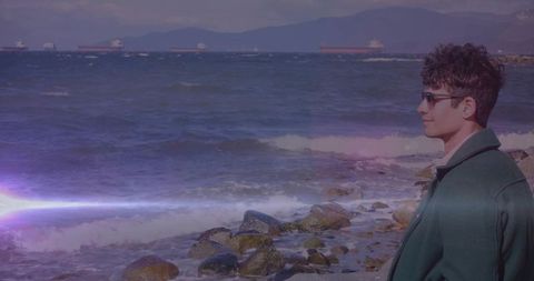 Pensive Man in Sunglasses Gazing Out at Calm Sea