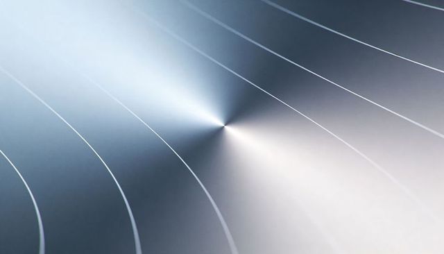 Brushed metal disk reflecting light with concentric grooves and central dimple
