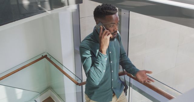 Professional Man Talking on Mobile Phone in Office Stairwell - Download Free Stock Images Pikwizard.com