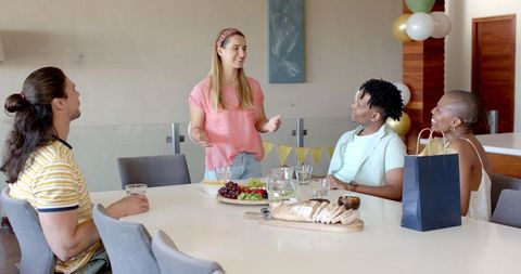 Friends Socializing at Home Gathering With Snacks and Drinks