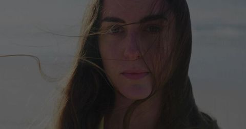 Woman Embracing Gentle Breeze at Coastal Beach Serenity