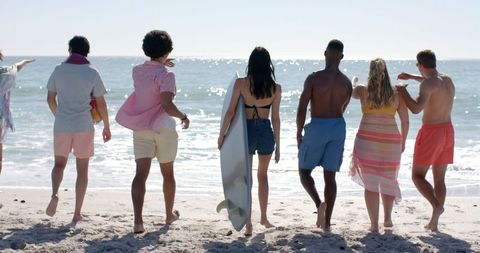 Group of Friends Enjoying a Sunny Day at Sandy Beach - Download Free Stock Images Pikwizard.com