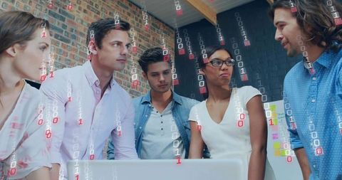 Collaborating tech team leaning over laptop with binary data overlay in modern coworking office