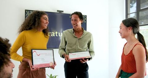 Diverse team celebrating employee achievement with smiling faces