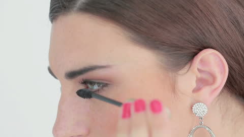 Woman Smiling While Applying Mascara