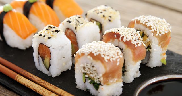 Close-Up of Sushi Rolls with Soy Sauce and Chopsticks on Slate - Download Free Stock Images Pikwizard.com