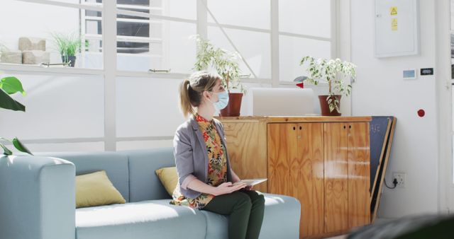 Woman Waiting in Office Lobby Wearing Mask Holding Tablet - Download Free Stock Images Pikwizard.com