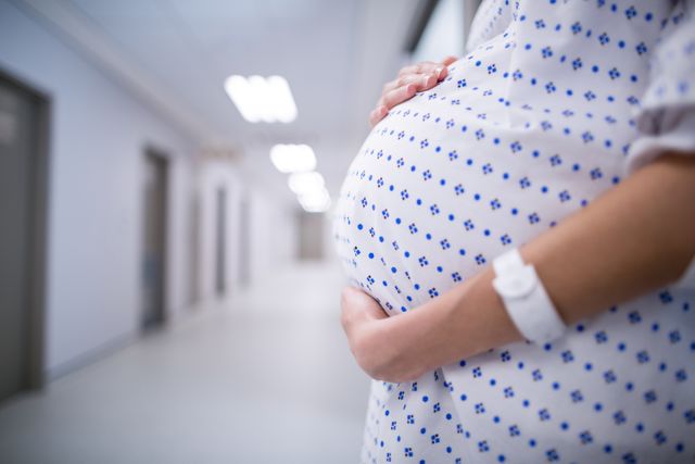 Pregnant Woman Standing in Hospital Corridor - Download Free Stock Photos Pikwizard.com