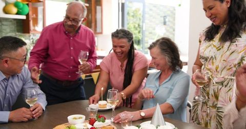 Senior Friends Celebrate Birthday with Cake and Champagne