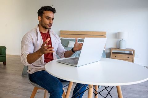 Man engaged in virtual meeting at home office