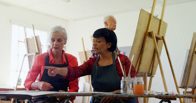Art Teacher Giving Instructions to Senior Woman in Painting Class - Download Free Stock Images Pikwizard.com