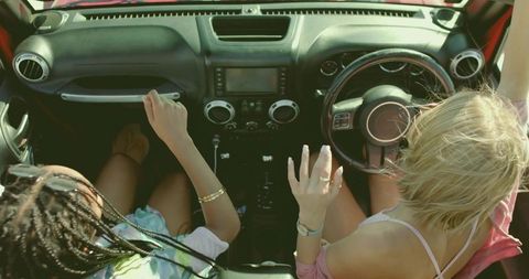Two Friends Enjoying Sunrise Road Trip in Convertible Car