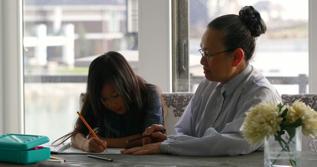 Grandmother Assisting Granddaughter with Homework at Home - Download Free Stock Images Pikwizard.com