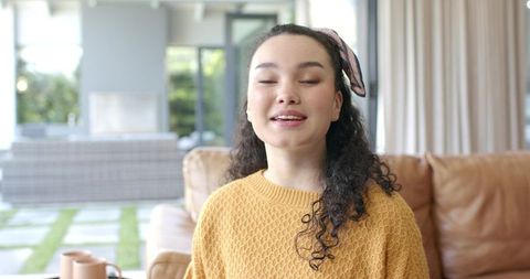 Young woman enjoying relaxed moment at home in cozy sweater