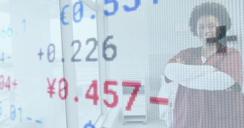 Nurse standing with arms crossed by window with currency and stock data overlay, headset