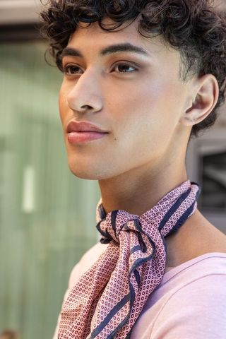 Stylish man wearing silk scarf exuding sophistication