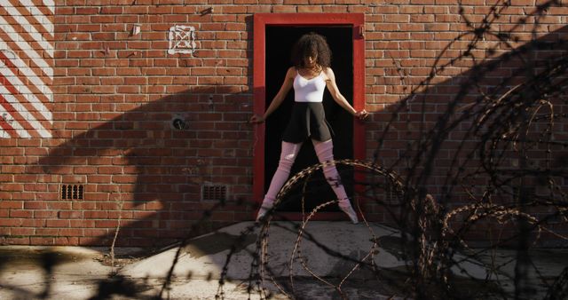 Biracial female dancer dancing in sunny brick courtyard, copy space - Download Free Stock Photos Pikwizard.com