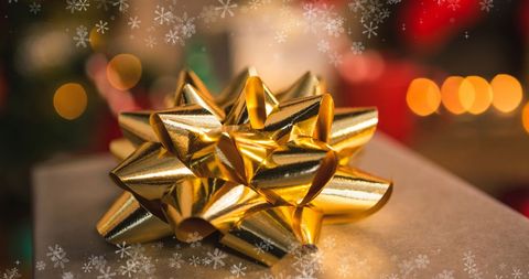 Golden Bow Sitting Atop Wrapped Christmas Gift in Festive Bokeh - Download Free Stock Images Pikwizard.com