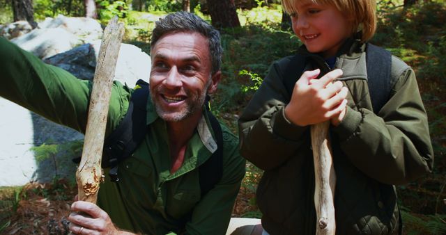 Father and Son Hiking in Forest with Wooden Sticks - Download Free Stock Images Pikwizard.com