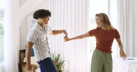 Couple dancing together in cozy bedroom setting