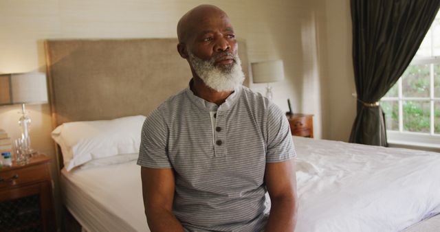 Thoughtful Mature Man Sitting on Bed in Bright Bedroom - Download Free Stock Images Pikwizard.com