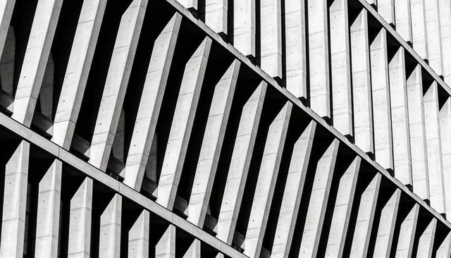 Diagonal Brutalist Concrete Facade Showing Repeating Fins, Louvers and Geometric Shadows