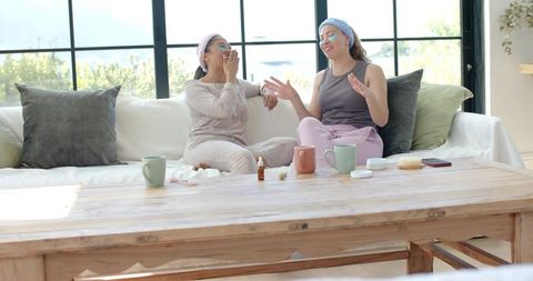 African american friends relaxing and laughing during at-home skincare spa morning with eye patches