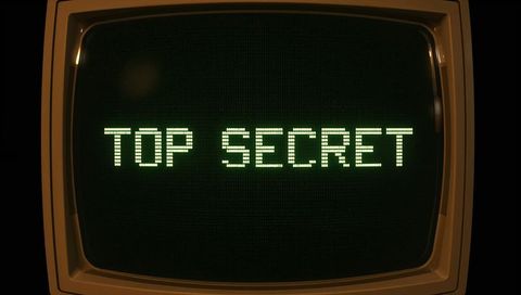 Vintage crt monitor displaying top secret green dot-matrix text with phosphor glow
