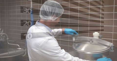 Technician managing industrial stainless steel tank in laboratory setting