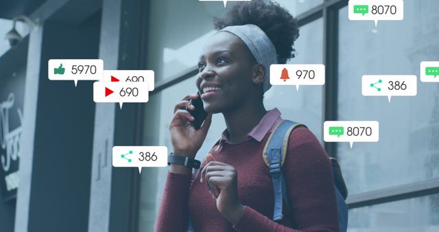 African American woman talking on phone, surrounded by social media engagement icons like likes and notifications. Represents digital interaction, connecting with followers, modern communication trends. Ideal for articles on social media influence, communication, online behavior, marketing strategies.