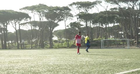 Soccer players in red uniforms practicing on sunny field