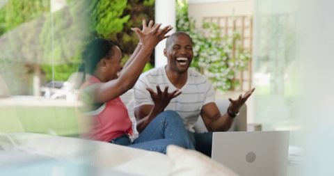 African American Couple Enjoying Conversation on Patio with Laptop